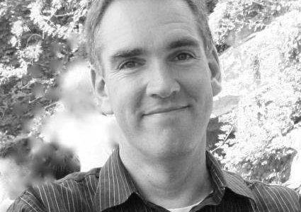 an image of a man in a striped shirt is smiling