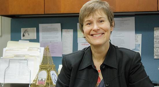 an image of a woman sitting at a desk with a laptop