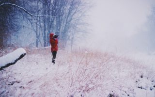 an image of a person in a red jacket standing in a snowy field