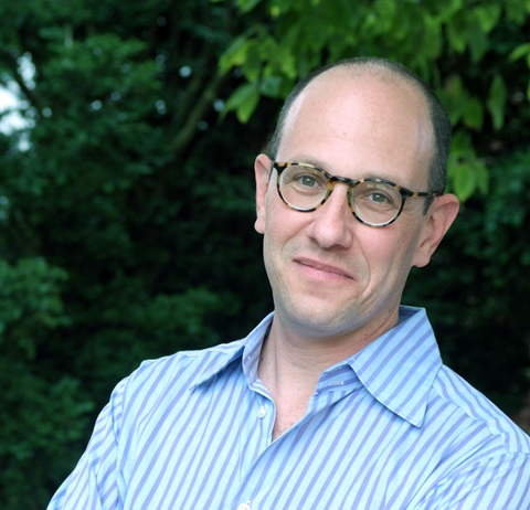 an image of a man with glasses and a blue shirt