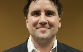an image of a man in a suit and tie smiling