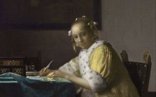 an image of a woman writing a letter at a table